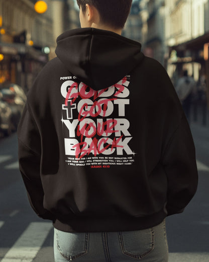 Person wearing a black hoodie with text on the back in an urban setting