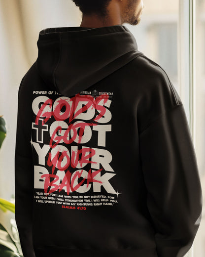 Person wearing a black hoodie with text on the back, standing indoors.