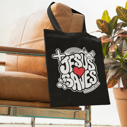 Black tote bag with 'Jesus Saves' design on a couch