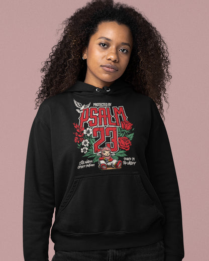 Person wearing a black hoodie with a graphic design on a pink background