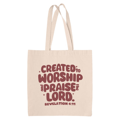 Natural Beige canvas tote bag with red text 'Created to Worship and Praise the Lord. Revelation 4:11' on a white background