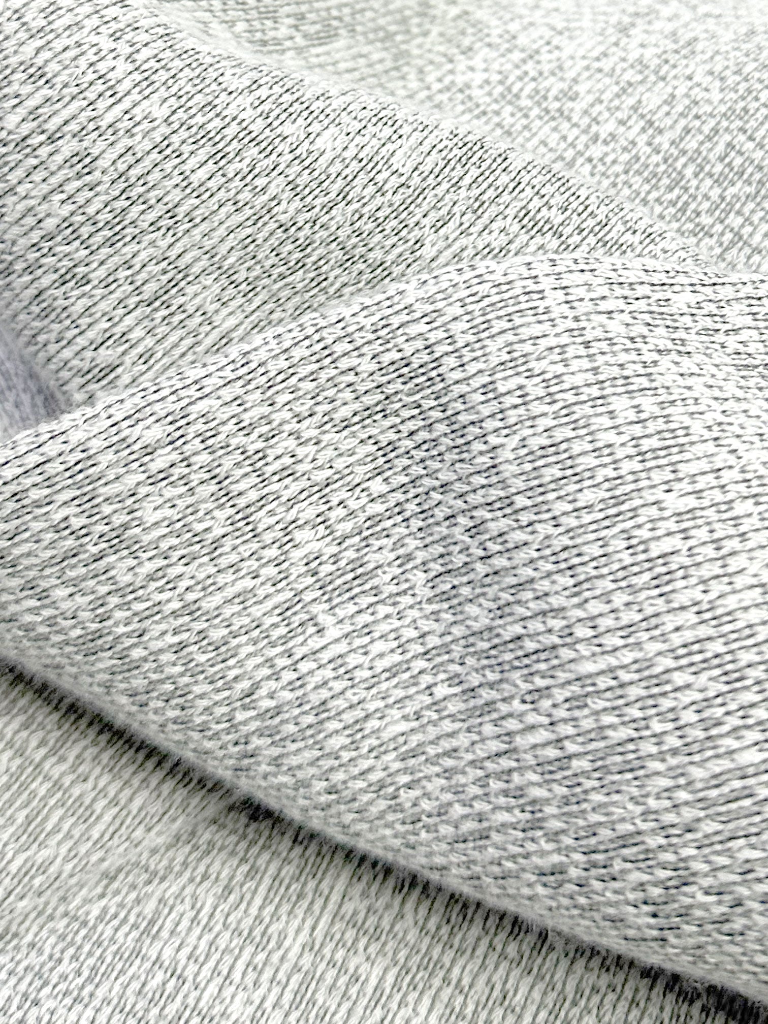Close-up of mix stone black and white ultra soft plush knit textured fabric with a folded pattern