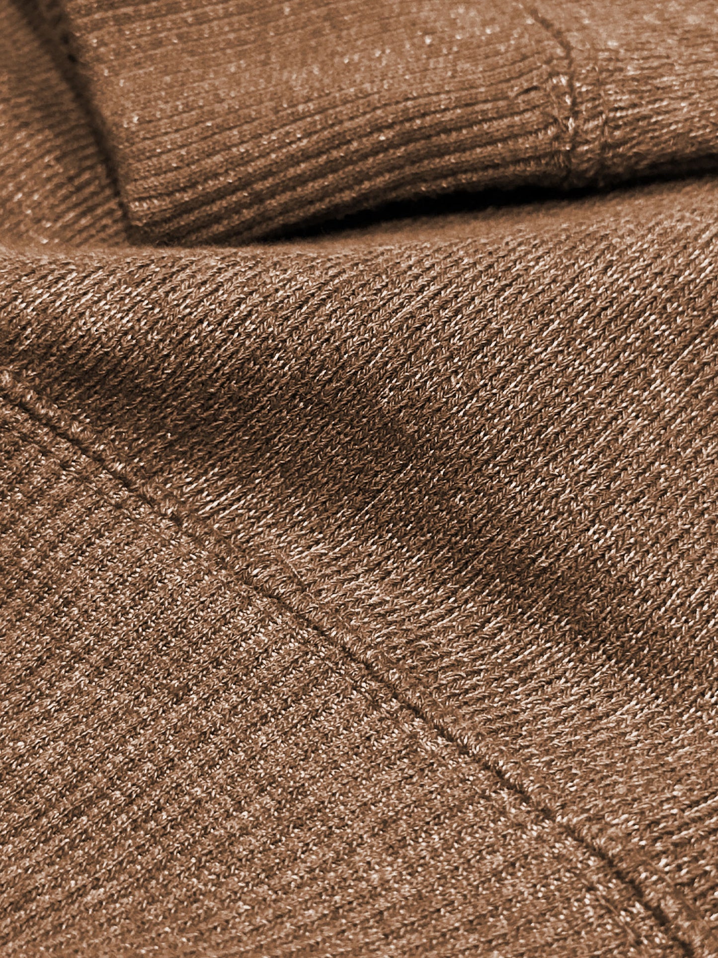 Close-up of terra brown ultra soft plush knit textured fabric with a folded pattern