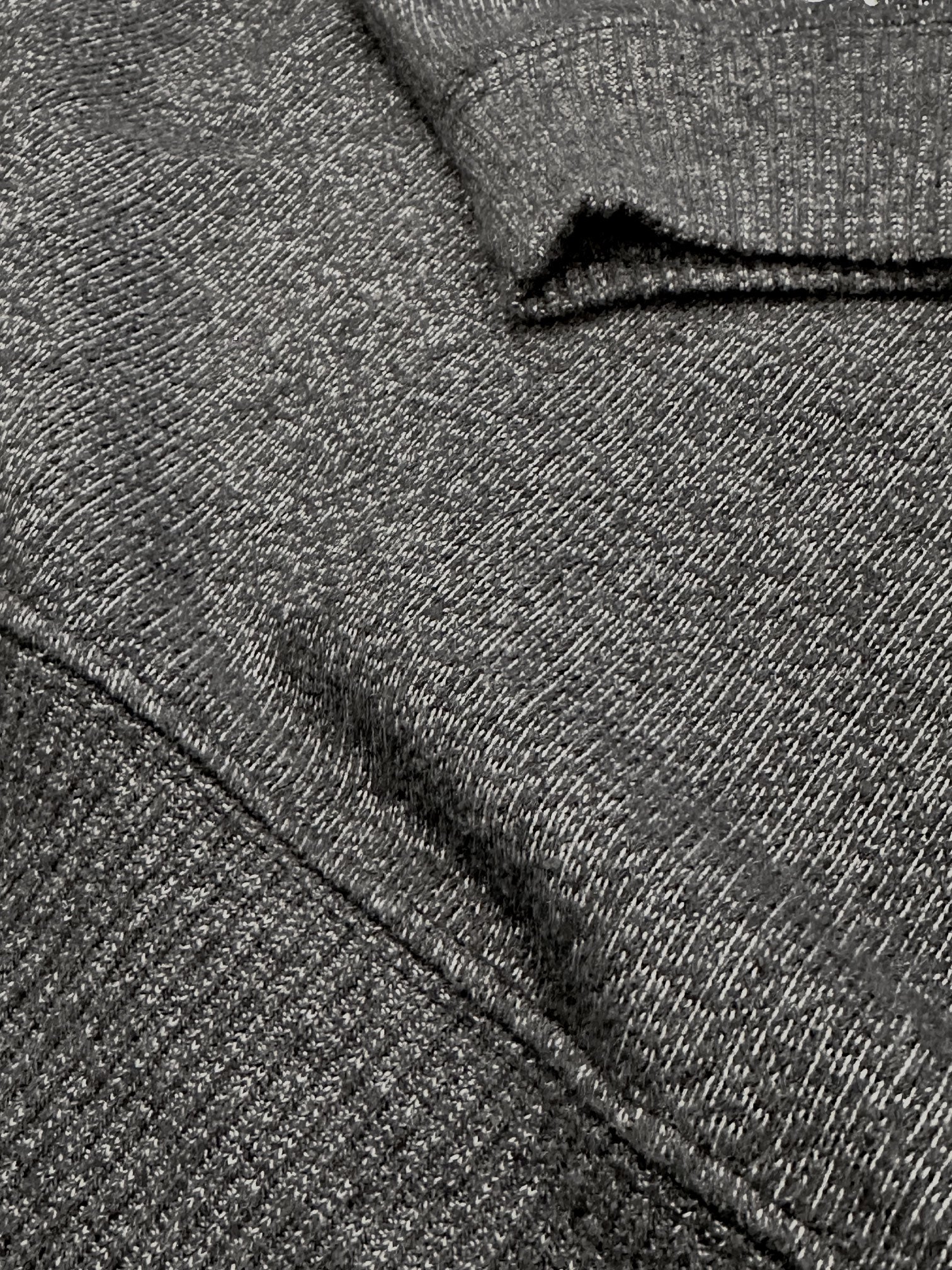 Close-up of dark grey ultra soft plush knit textured fabric with a folded pattern